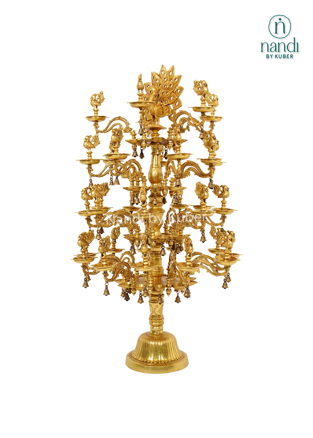 Large handcrafted brass Deepam with multiple oil lamp tiers, peacock motifs, floral detailing, and hanging bells for temples and pooja spaces.