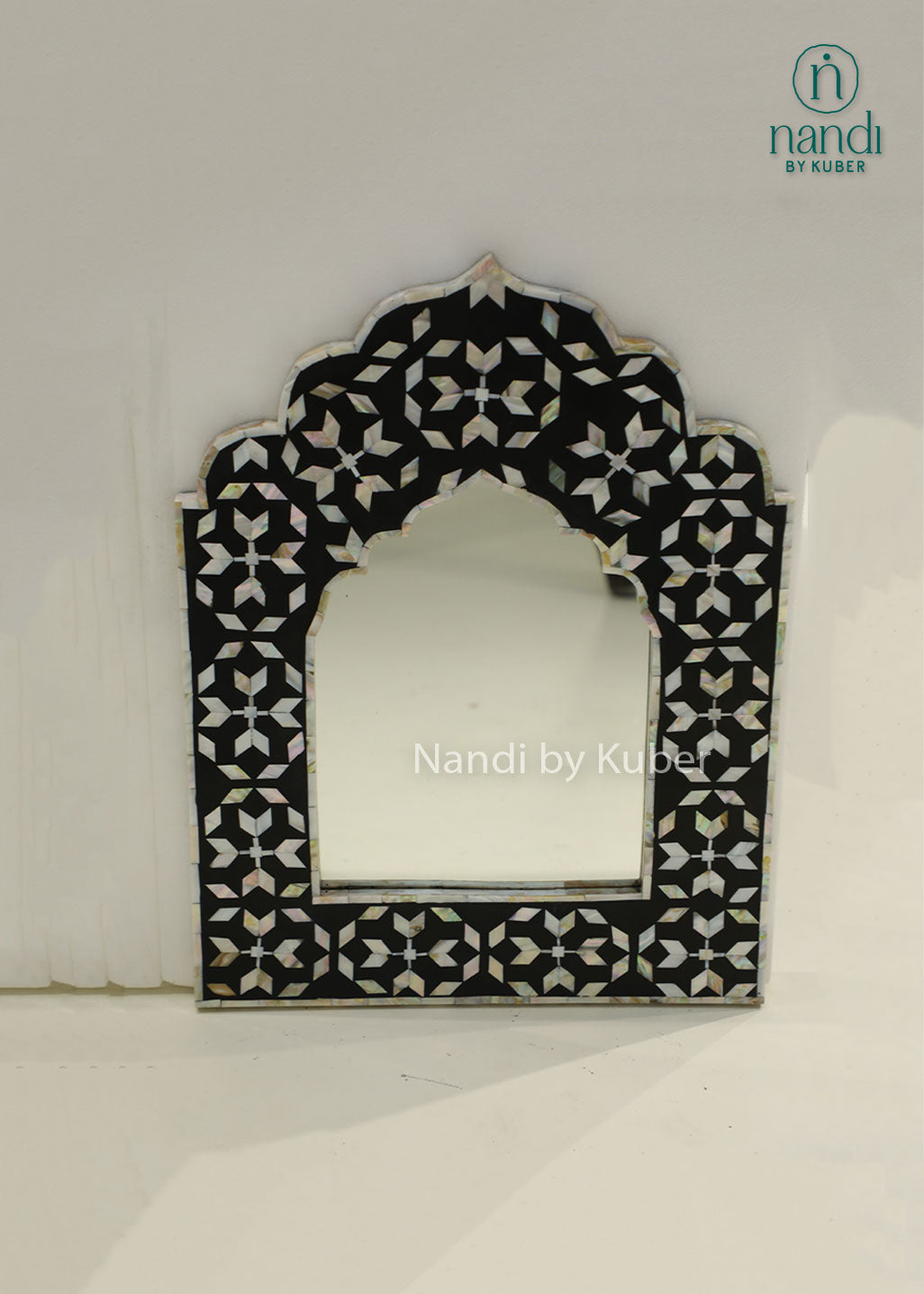 Elegant mother-of-pearl mirror frame with intricate geometric inlay and an arched design, adding timeless sophistication to any interior.