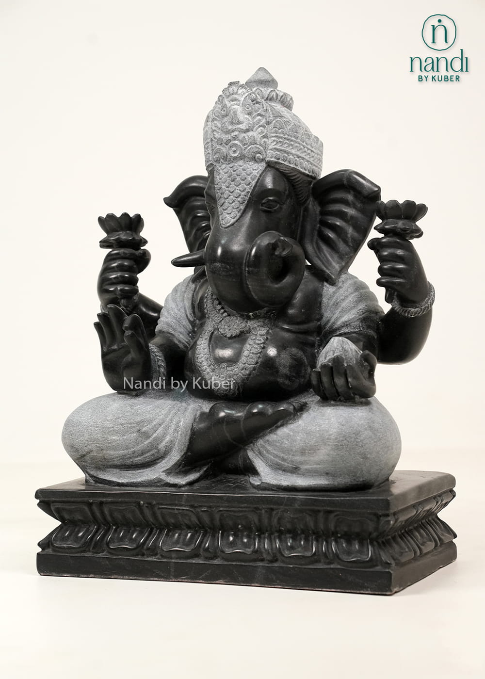 Black and white marble-style Lord Ganesha statue with intricate carvings, lotus motifs, and an elegant dual-tone finish.