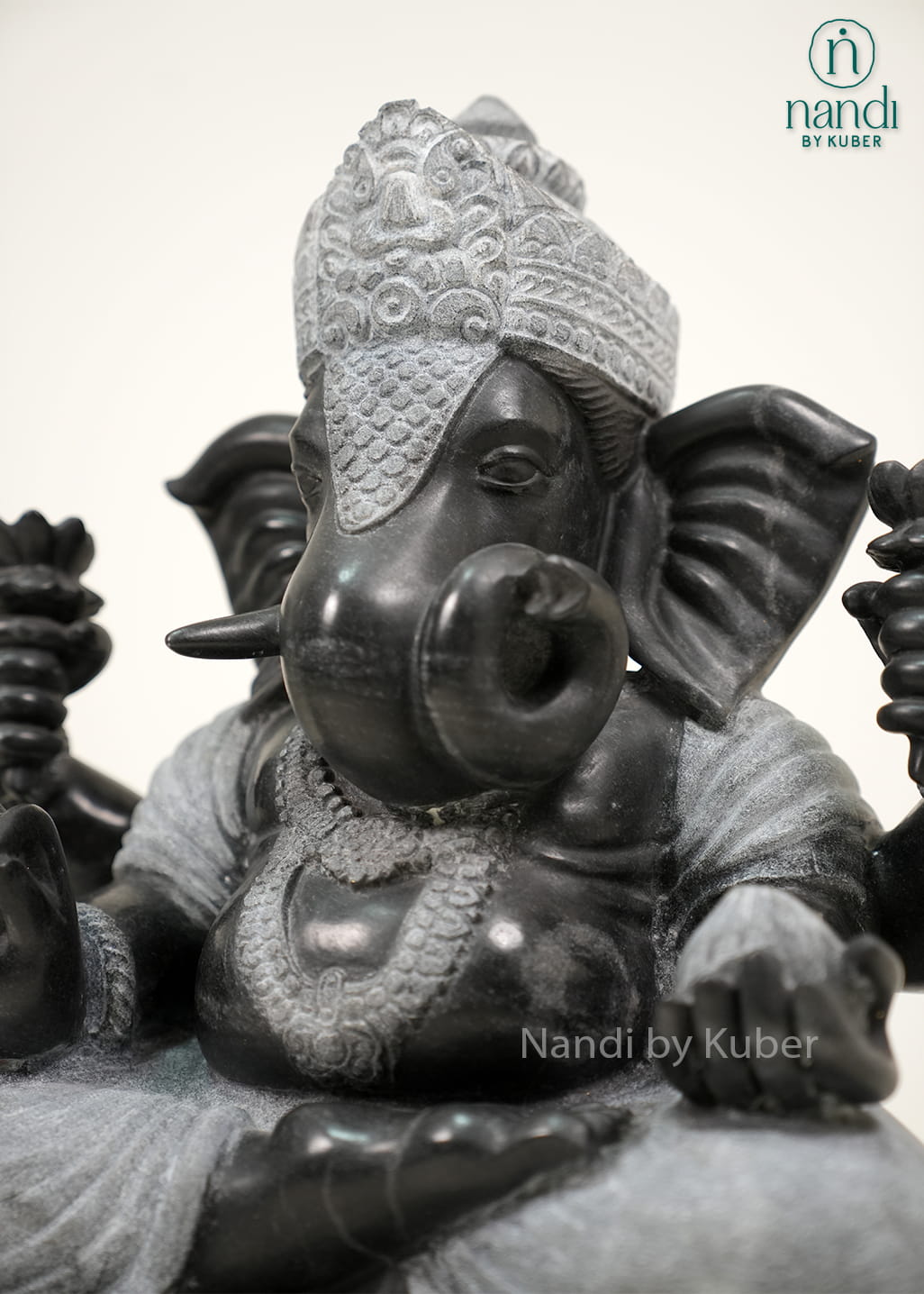Black and white marble-style Lord Ganesha statue with intricate carvings, lotus motifs, and an elegant dual-tone finish.