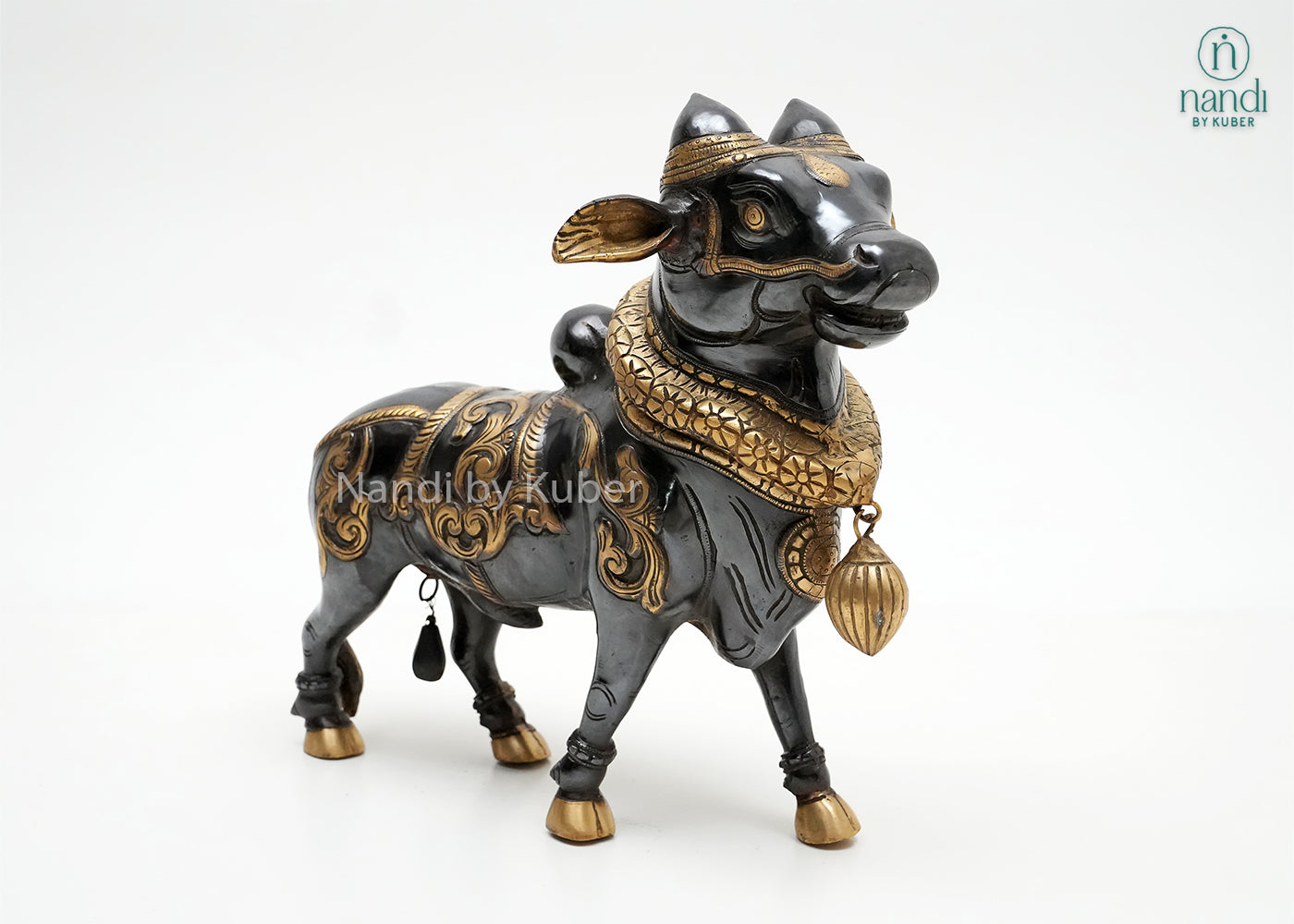 Handcrafted Nandi bull figurine with black and gold detailing, traditional ornamental carvings, and decorative pendant, ideal for spiritual décor, temple-inspired interiors, and collectible displays.