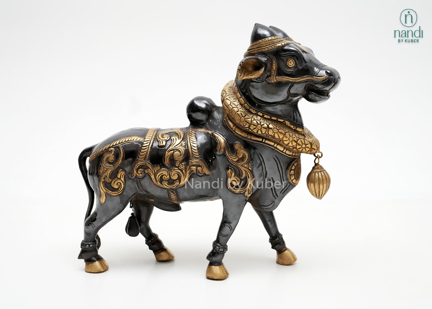 Handcrafted Nandi bull figurine with black and gold detailing, traditional ornamental carvings, and decorative pendant, ideal for spiritual décor, temple-inspired interiors, and collectible displays.