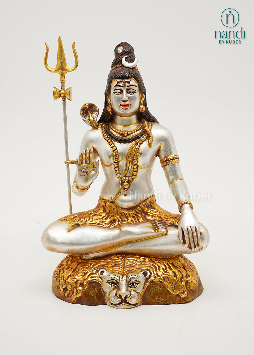 Handcrafted silver and gold finish Lord Shiva meditation statue with trident and sacred serpent, seated on an ornate tiger-inspired base, ideal for home temples, spiritual décor, yoga spaces, and devotional gifting.