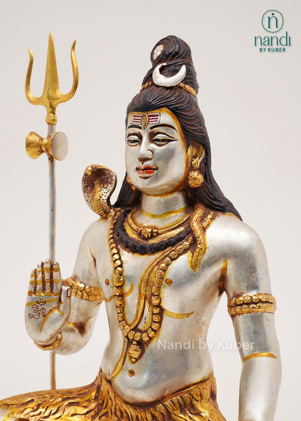 Handcrafted silver and gold finish Lord Shiva meditation statue with trident and sacred serpent, seated on an ornate tiger-inspired base, ideal for home temples, spiritual décor, yoga spaces, and devotional gifting.
