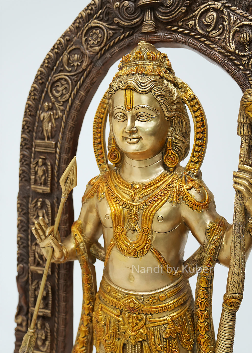 Handcrafted three-tone brass Lord Ram idol with bow and arrow under an intricately carved temple arch, featuring traditional Hindu artistry, ideal for home temples, spiritual décor, devotional worship, and religious gifting.