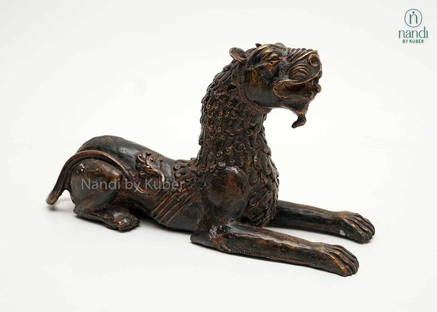 Decorative brass tiger statue in a reclining pose with an antique finish, symbolizing strength, courage, and power.