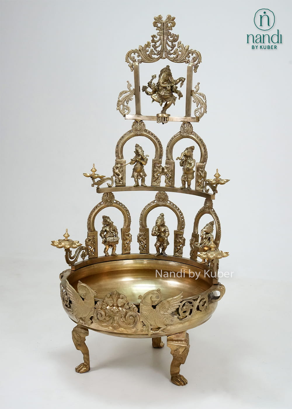 Decorative brass Ganesha urli with temple arch design, diya holders, and intricate detailing
