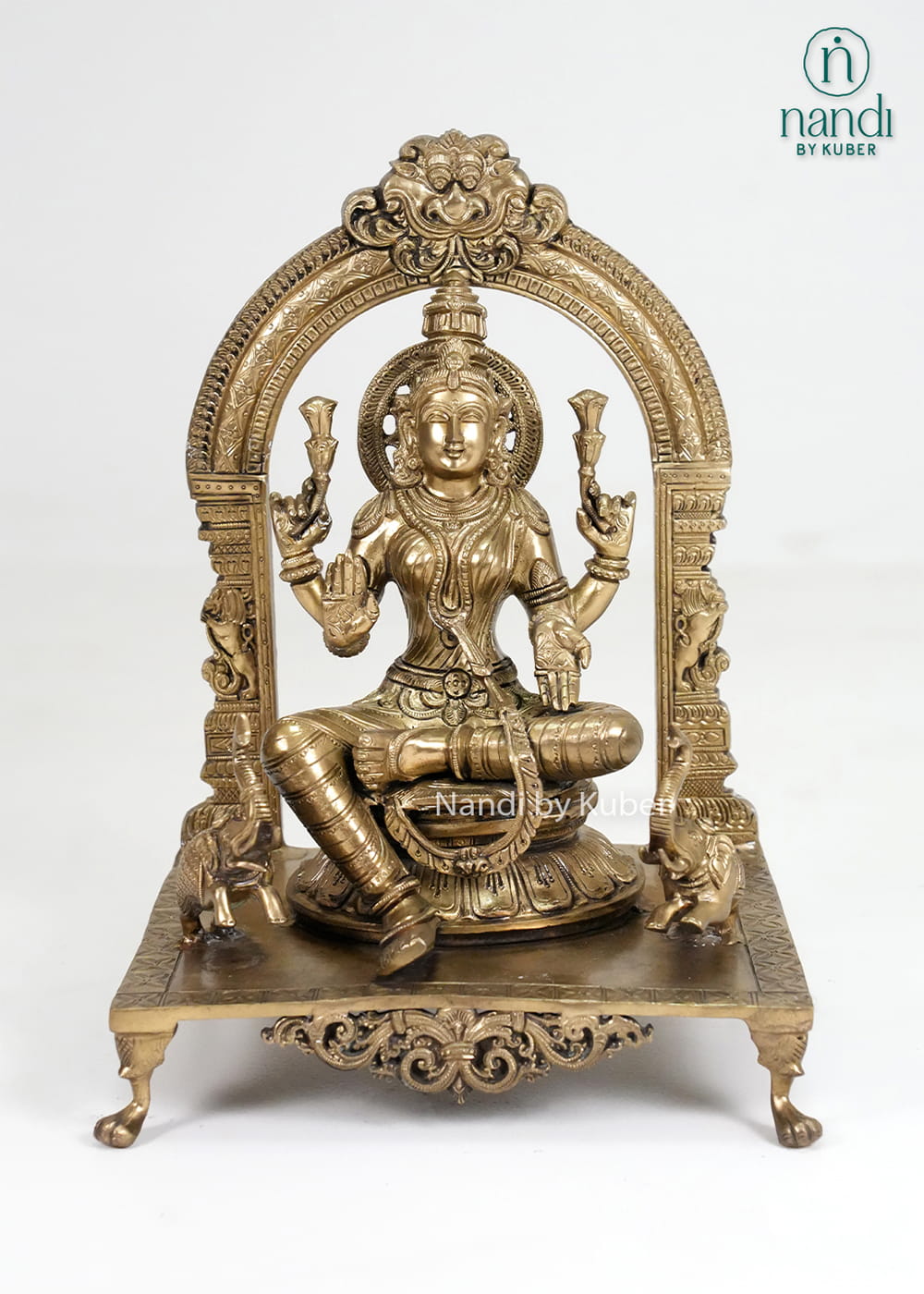 Bronze Mariamman statue with ornate arch and traditional temple-style detailing