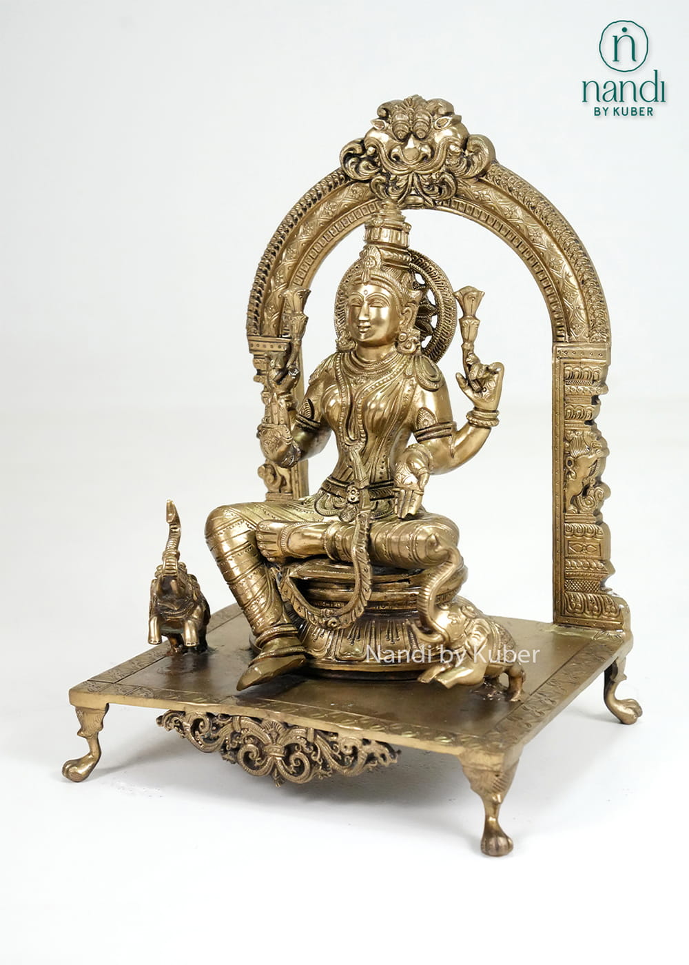 Bronze Mariamman statue with ornate arch and traditional temple-style detailing