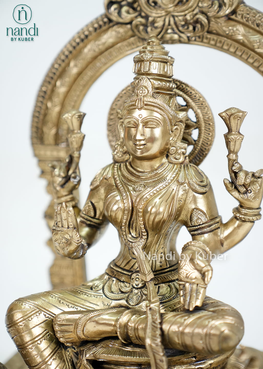 Bronze Mariamman statue with ornate arch and traditional temple-style detailing