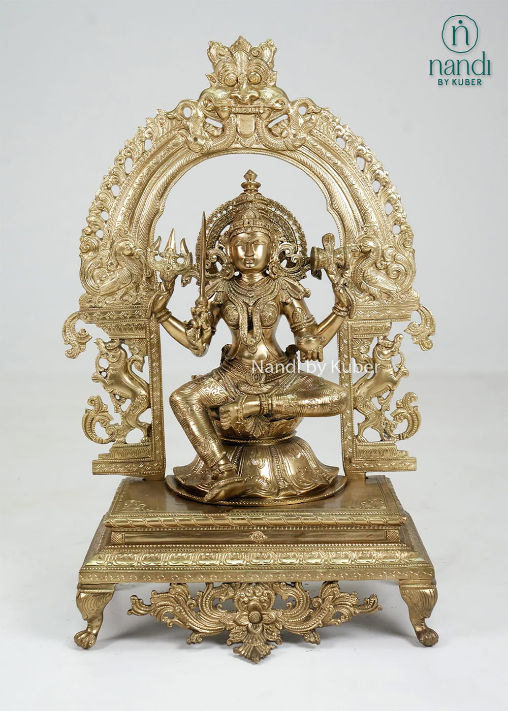 Bronze Mariamman statue with ornate arch and traditional temple-style detailing