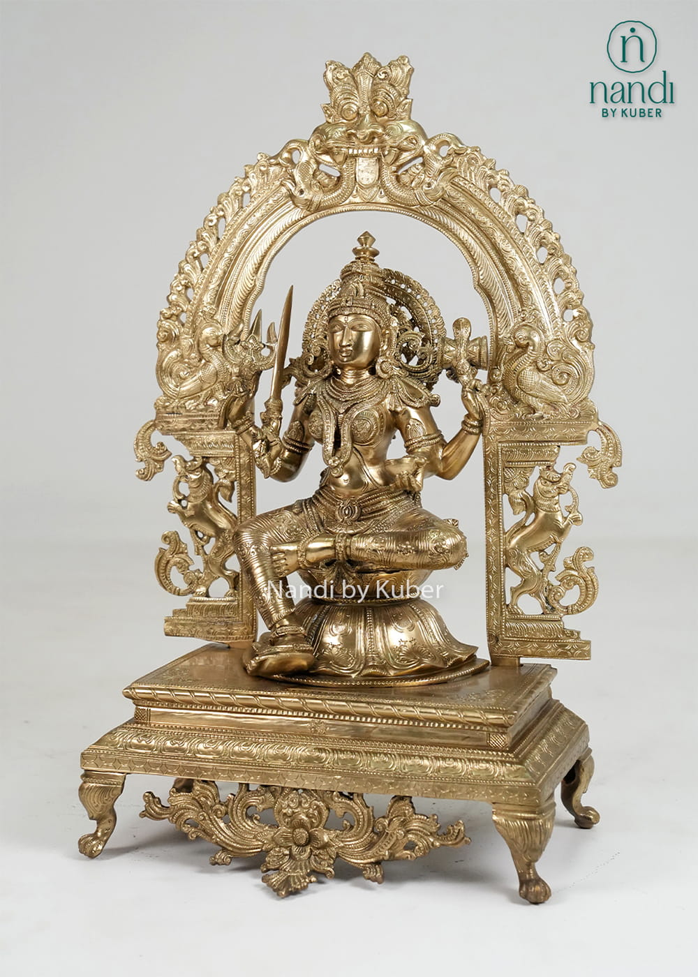 Bronze Mariamman statue with ornate arch and traditional temple-style detailing