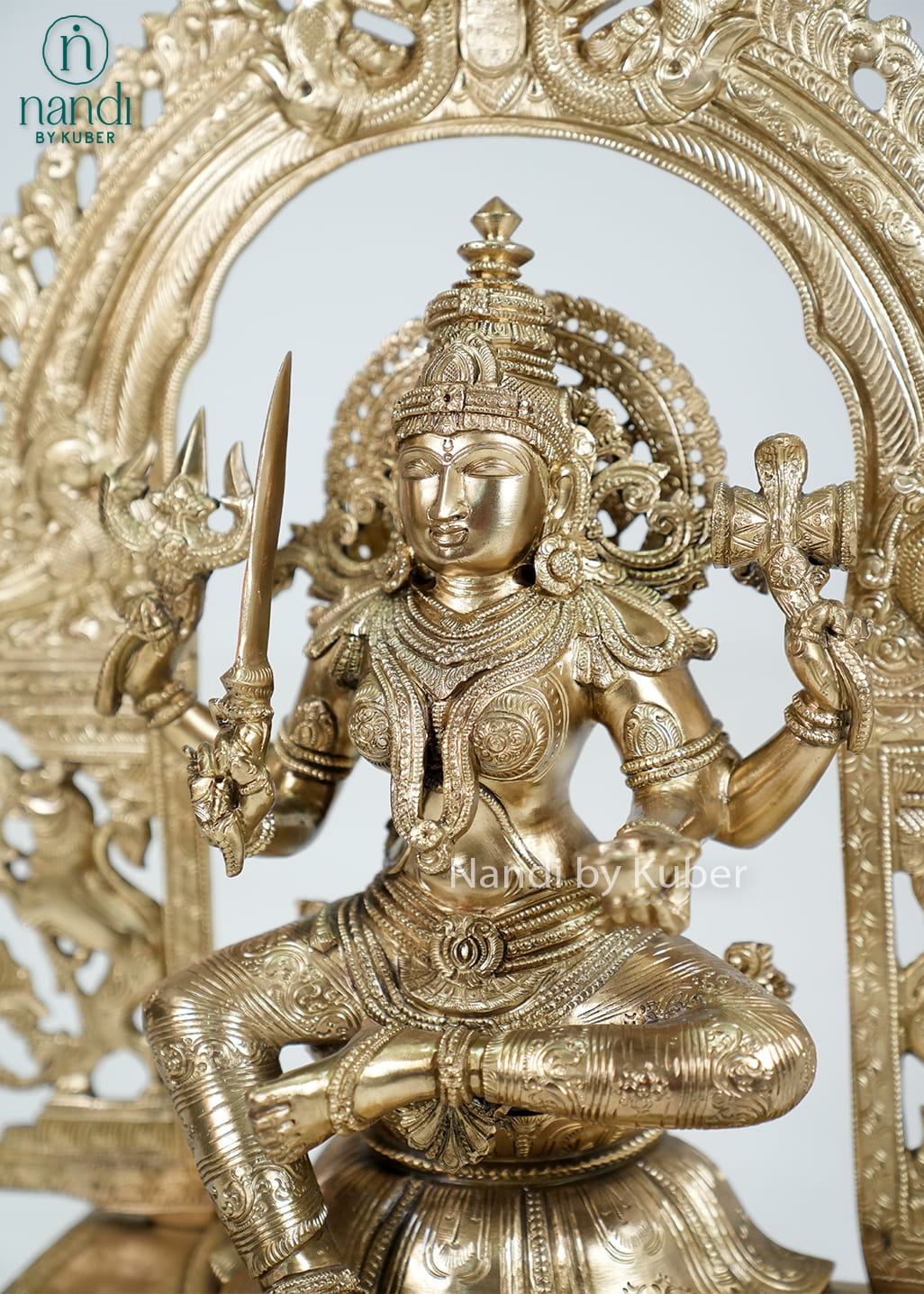 Bronze Mariamman statue with ornate arch and traditional temple-style detailing