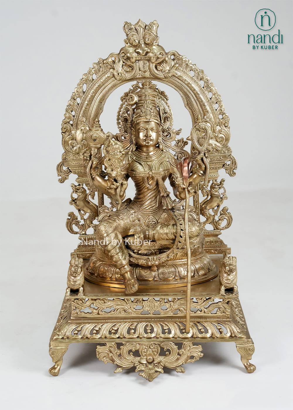 Bronze Rajarajeshwari Devi statue with ornate arch and temple-style detailing