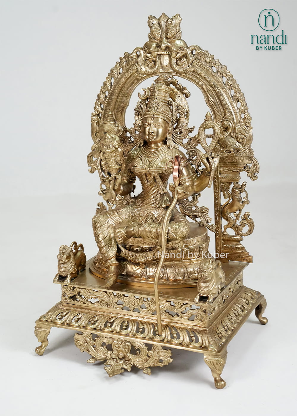 Bronze Rajarajeshwari Devi statue with ornate arch and temple-style detailing