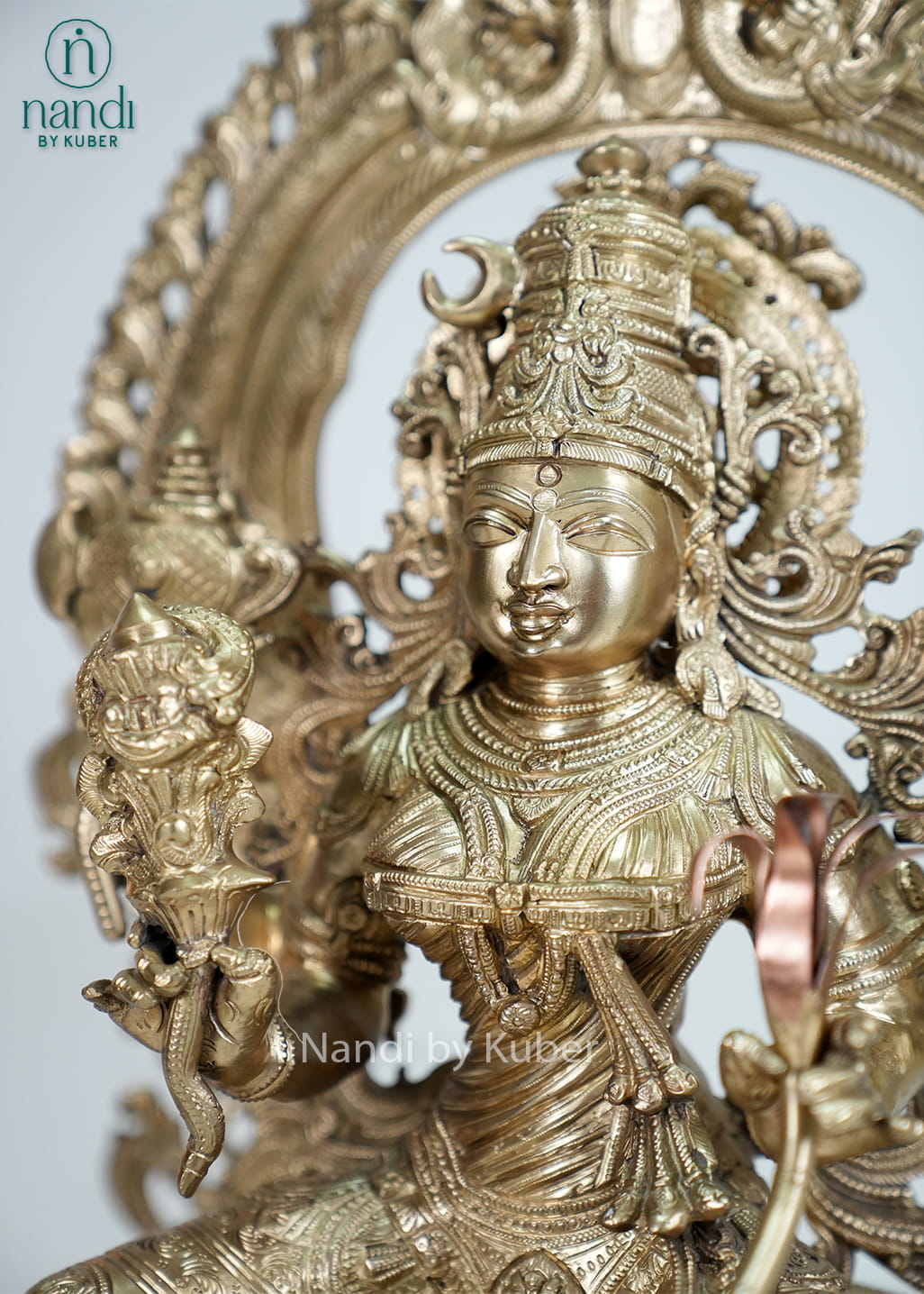 Bronze Rajarajeshwari Devi statue with ornate arch and temple-style detailing