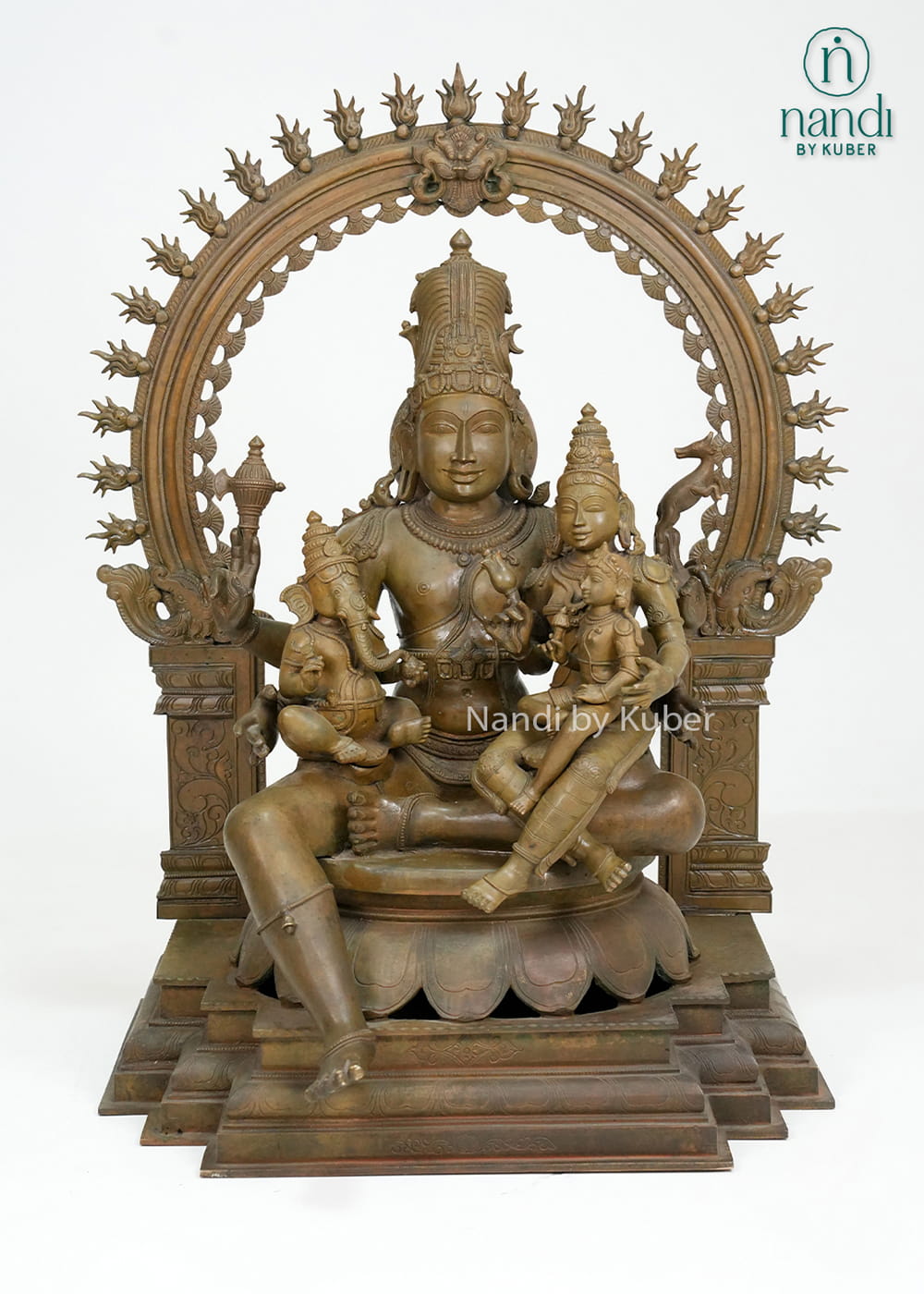 Bronze-finish Shiva Parvati family statue with Lord Ganesha, ornate arch detailing, and an intricately crafted pedestal base.