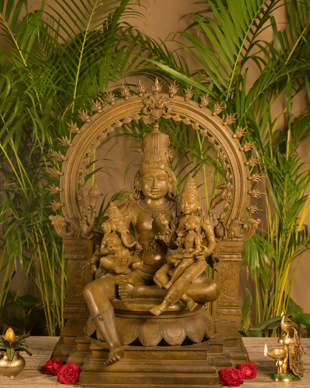 Bronze-finish Shiva Parvati family statue with Lord Ganesha, ornate arch detailing, and an intricately crafted pedestal base.
