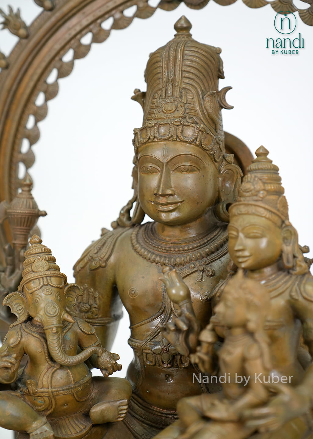 Bronze-finish Shiva Parvati family statue with Lord Ganesha, ornate arch detailing, and an intricately crafted pedestal base.