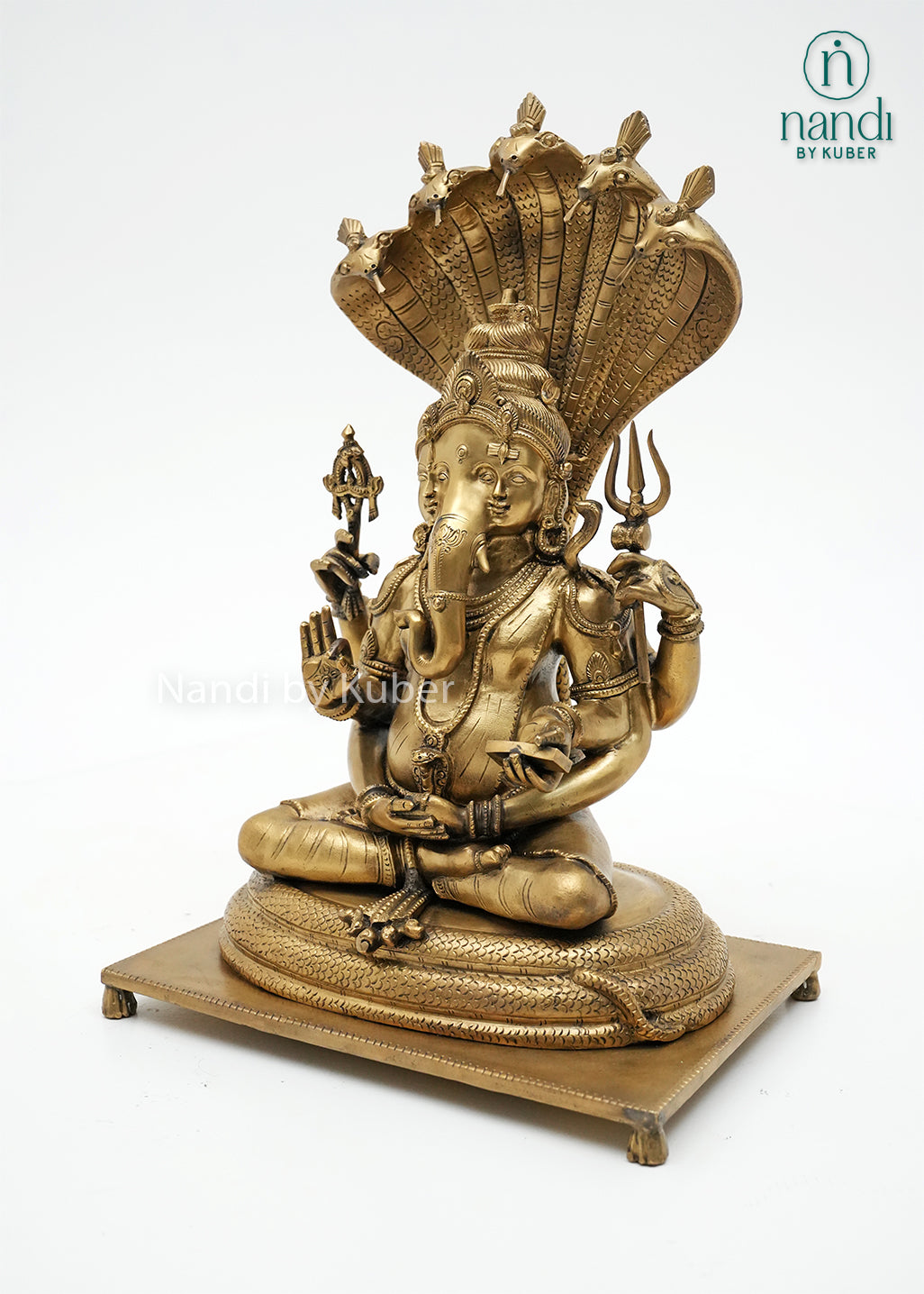Handcrafted bronze Trimurti Ganesha idol with serpent hood canopy, intricate Hindu symbolism, and detailed pedestal base, ideal for home temples, spiritual décor, devotional worship, and religious gifting.