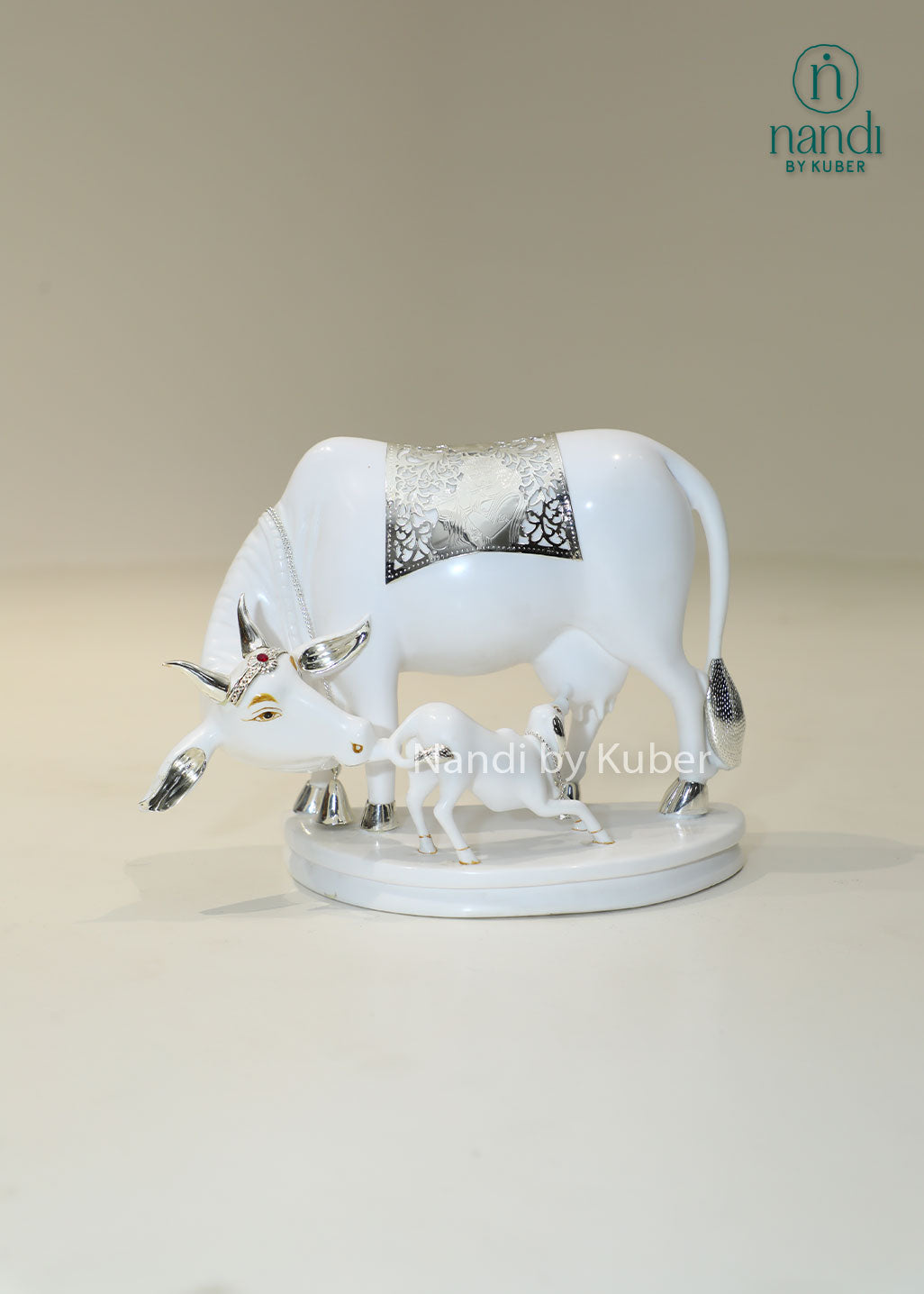 Marble Kamdhenu cow and calf idol with silver detailing for home temple, Vastu décor, spiritual worship, prosperity, wealth attraction, positive energy, divine blessings, pooja room decoration, and auspicious gifting.