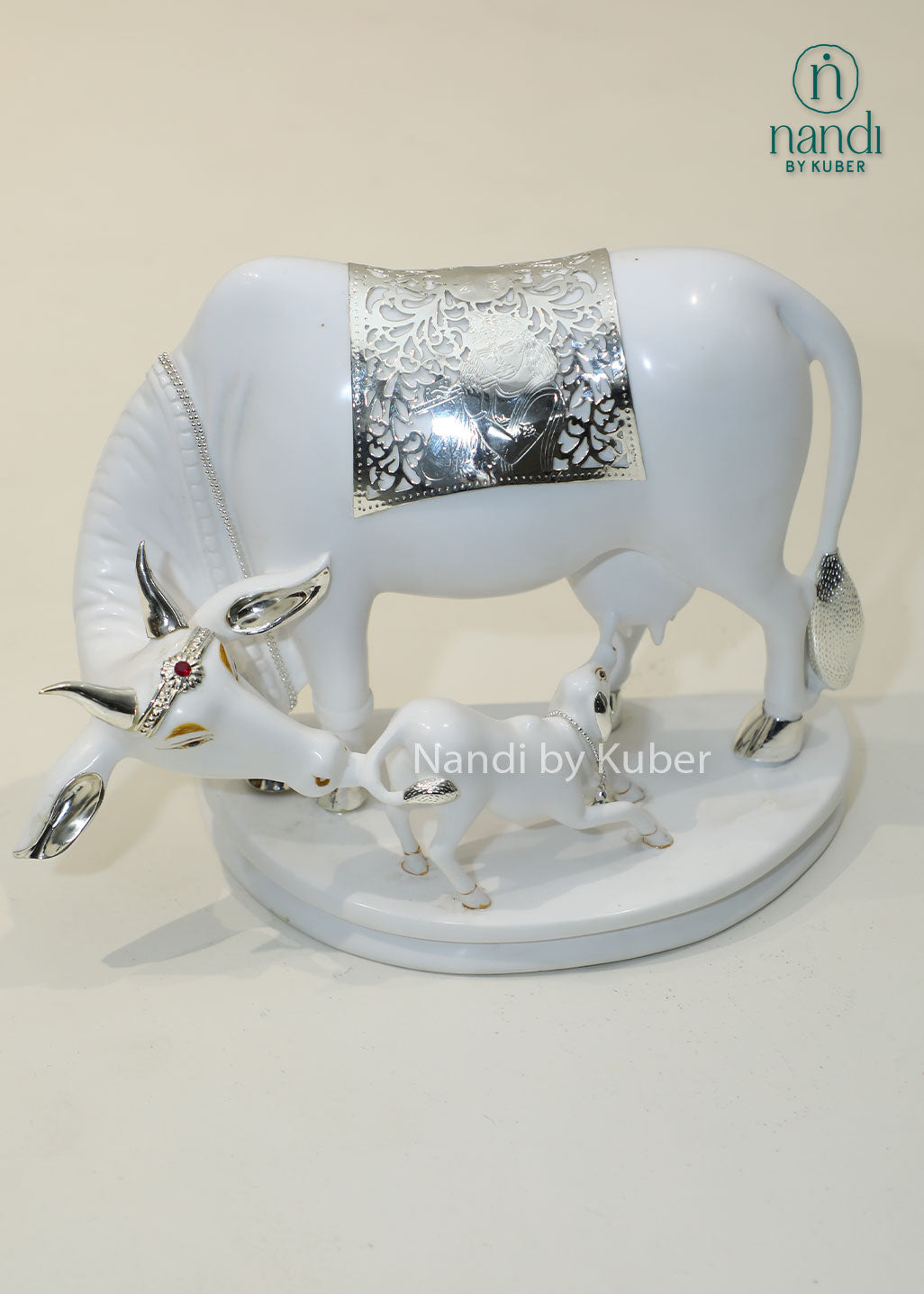 Marble Kamdhenu cow and calf idol with silver detailing for home temple, Vastu décor, spiritual worship, prosperity, wealth attraction, positive energy, divine blessings, pooja room decoration, and auspicious gifting.