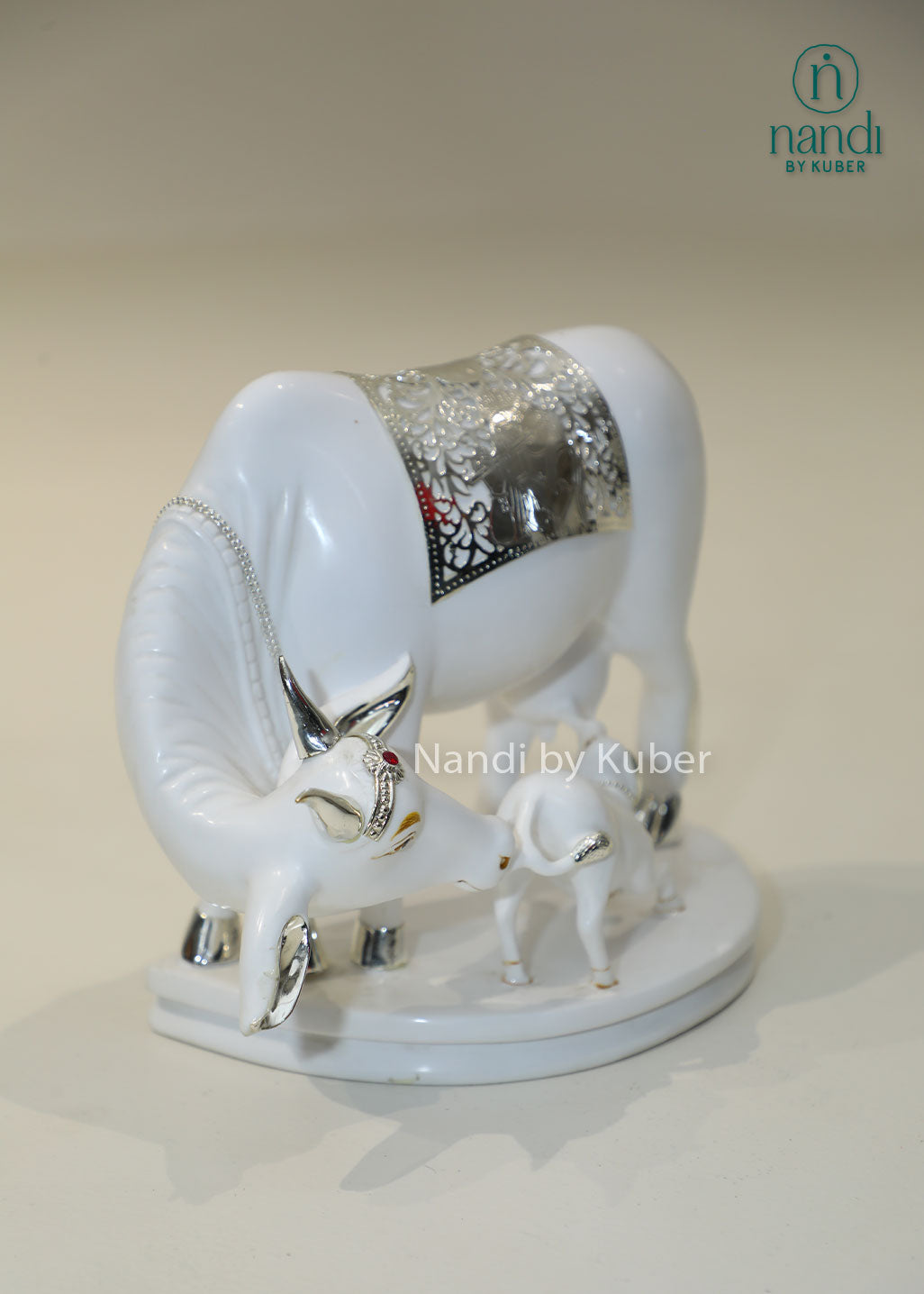 Marble Kamdhenu cow and calf idol with silver detailing for home temple, Vastu décor, spiritual worship, prosperity, wealth attraction, positive energy, divine blessings, pooja room decoration, and auspicious gifting.