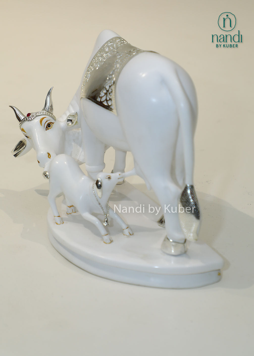 Marble Kamdhenu cow and calf idol with silver detailing for home temple, Vastu décor, spiritual worship, prosperity, wealth attraction, positive energy, divine blessings, pooja room decoration, and auspicious gifting.