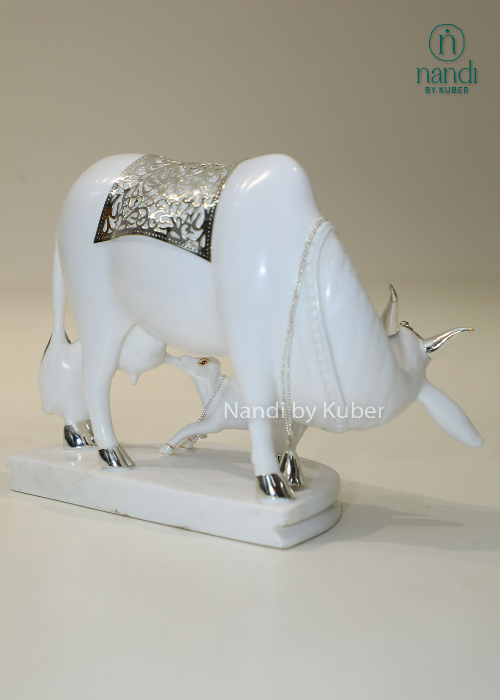 Marble Kamdhenu cow and calf idol with silver detailing for home temple, Vastu décor, spiritual worship, prosperity, wealth attraction, positive energy, divine blessings, pooja room decoration, and auspicious gifting.