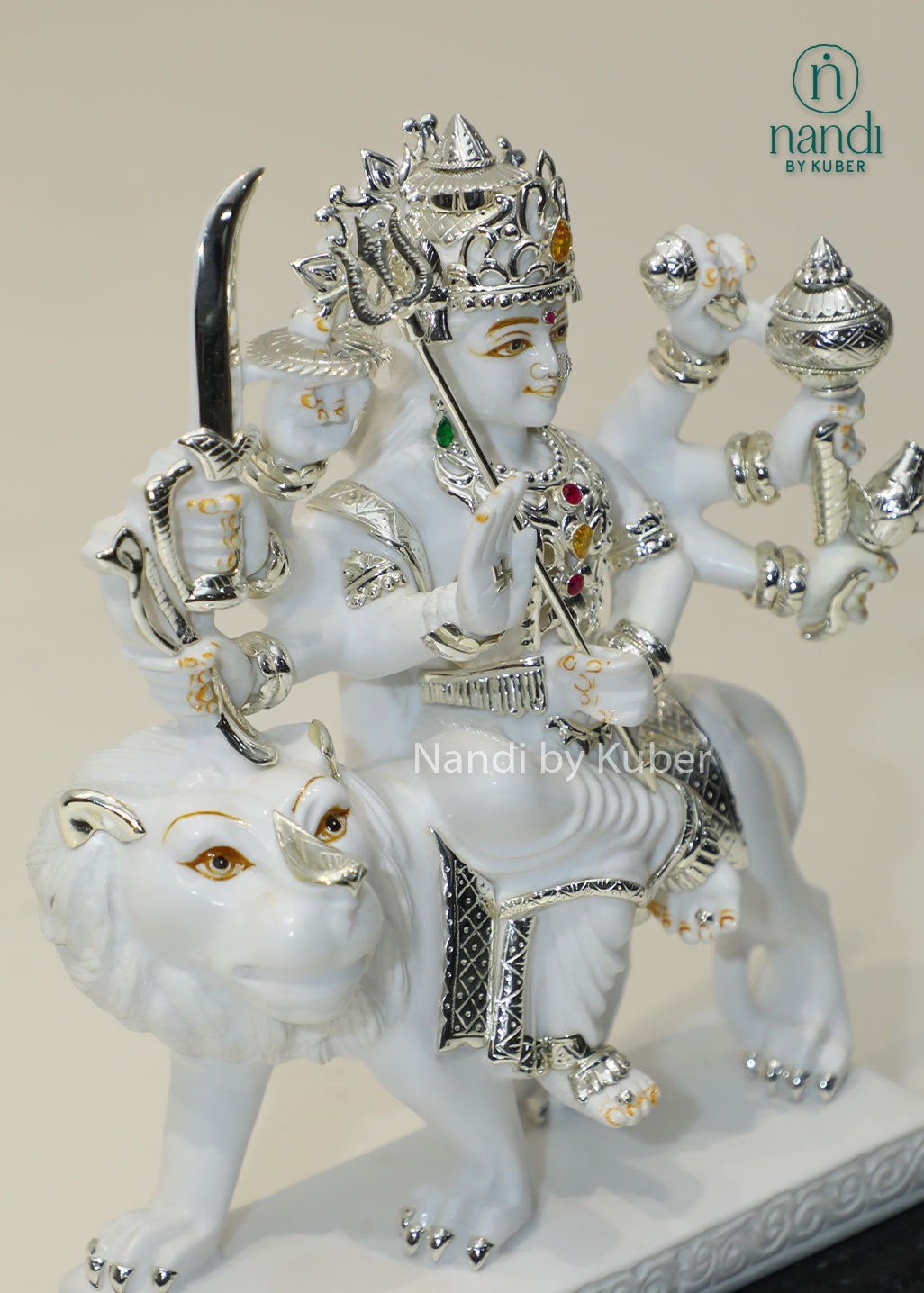 Handcrafted white marble Durga Maa statue on lion with silver and traditional craftsmanship, ideal for pooja rooms, spiritual décor, temple settings, and religious gifting.