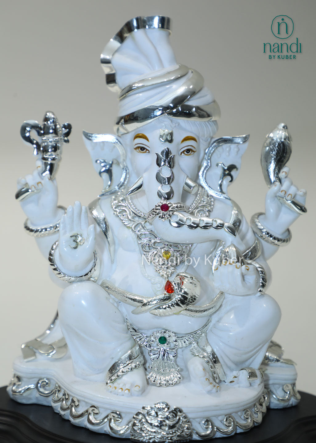 White marble Ganesha idol with silver detailing and gemstone accents, Lord Ganesh statue for home temple, pooja room décor, Vastu, prosperity, wealth attraction, positive energy, spiritual worship, festive gifting, and office decoration.