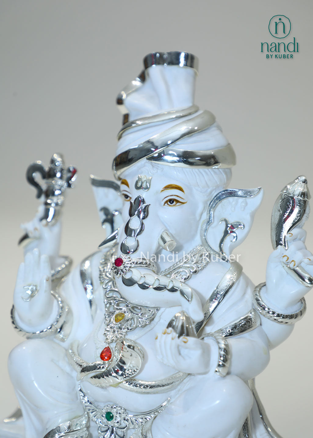 White marble Ganesha idol with silver detailing and gemstone accents, Lord Ganesh statue for home temple, pooja room décor, Vastu, prosperity, wealth attraction, positive energy, spiritual worship, festive gifting, and office decoration.