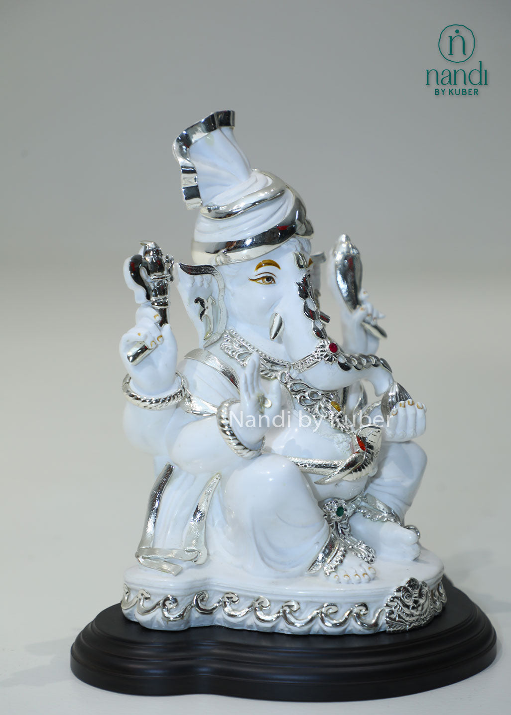 White marble Ganesha idol with silver detailing and gemstone accents, Lord Ganesh statue for home temple, pooja room décor, Vastu, prosperity, wealth attraction, positive energy, spiritual worship, festive gifting, and office decoration.