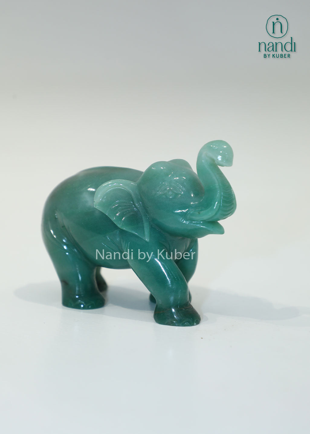Polished jade stone elephant with an upward trunk, symbolizing luck, prosperity, and wisdom while adding elegant charm to any décor.