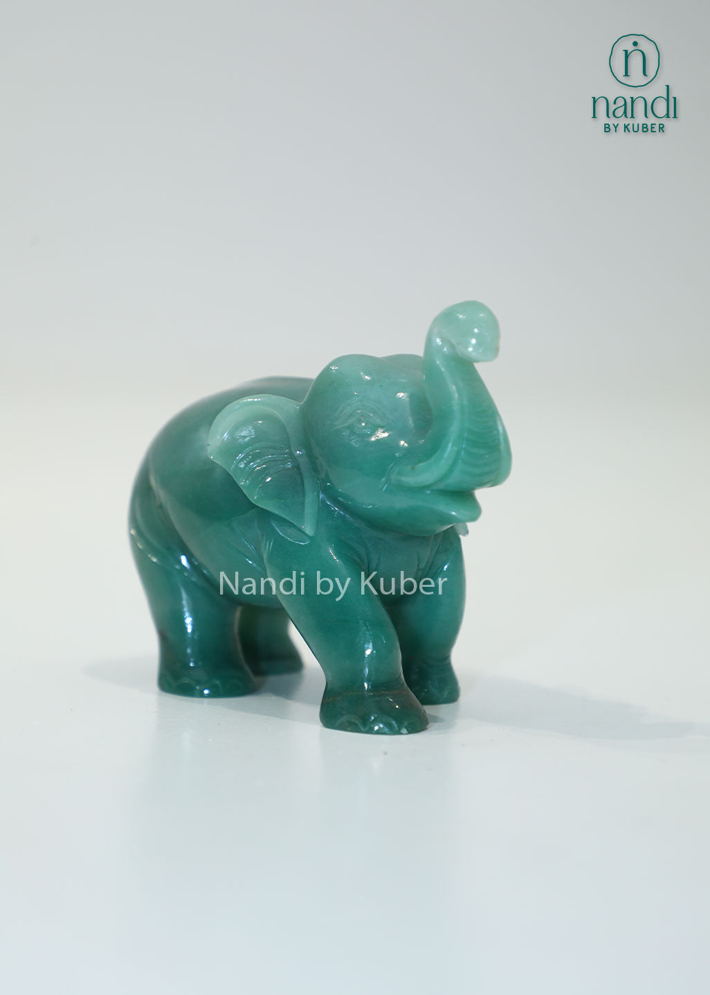 Polished jade stone elephant with an upward trunk, symbolizing luck, prosperity, and wisdom while adding elegant charm to any décor.
