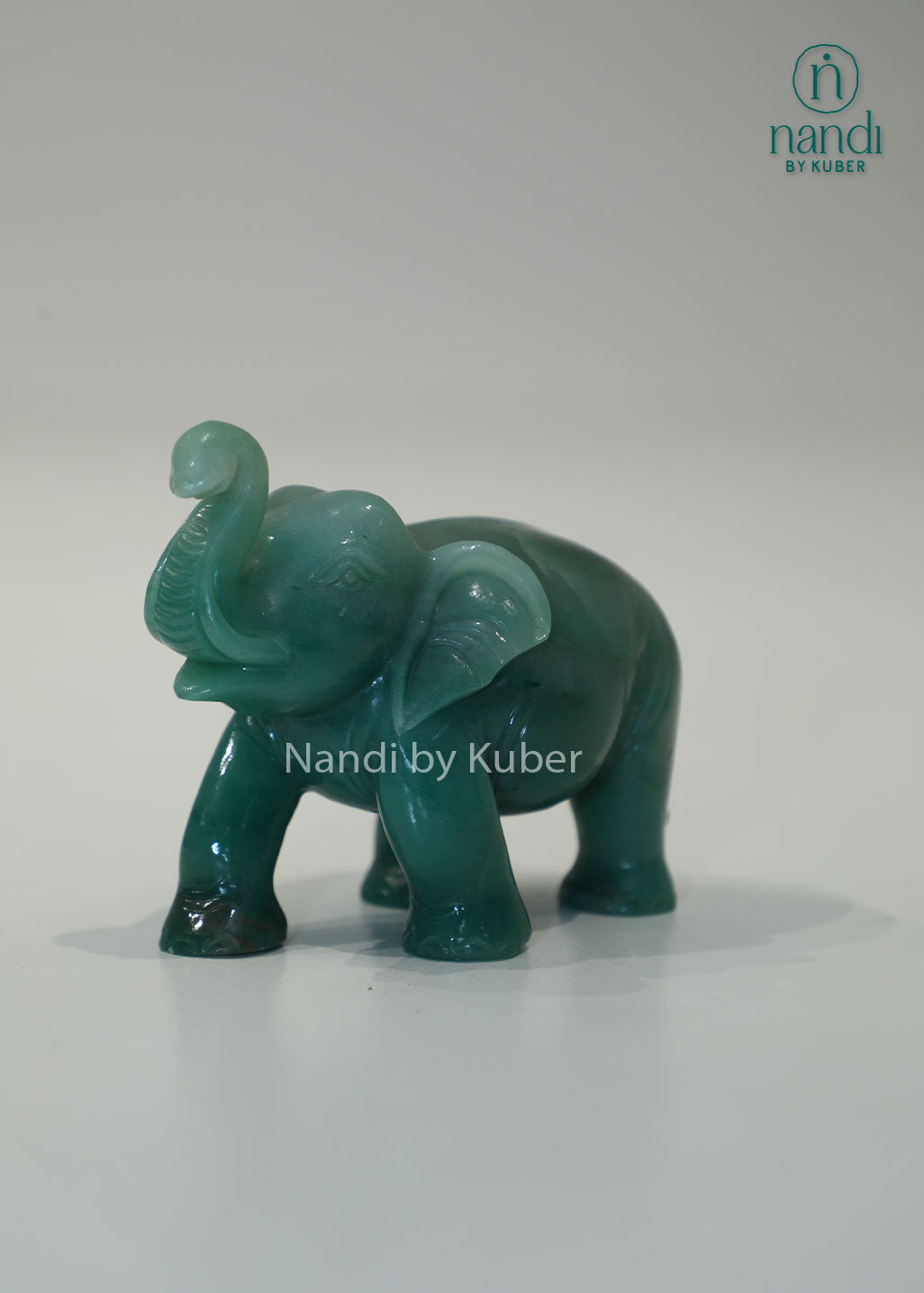 Polished jade stone elephant with an upward trunk, symbolizing luck, prosperity, and wisdom while adding elegant charm to any décor.
