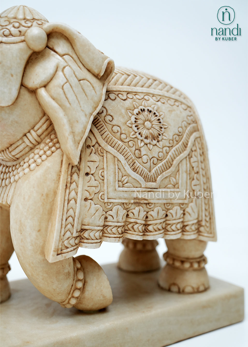 Handcrafted marble elephant statue with raised trunk, intricate traditional carvings, and decorative detailing on a marble base, ideal for home décor, Vastu, gifting, and luxury interior decoration.