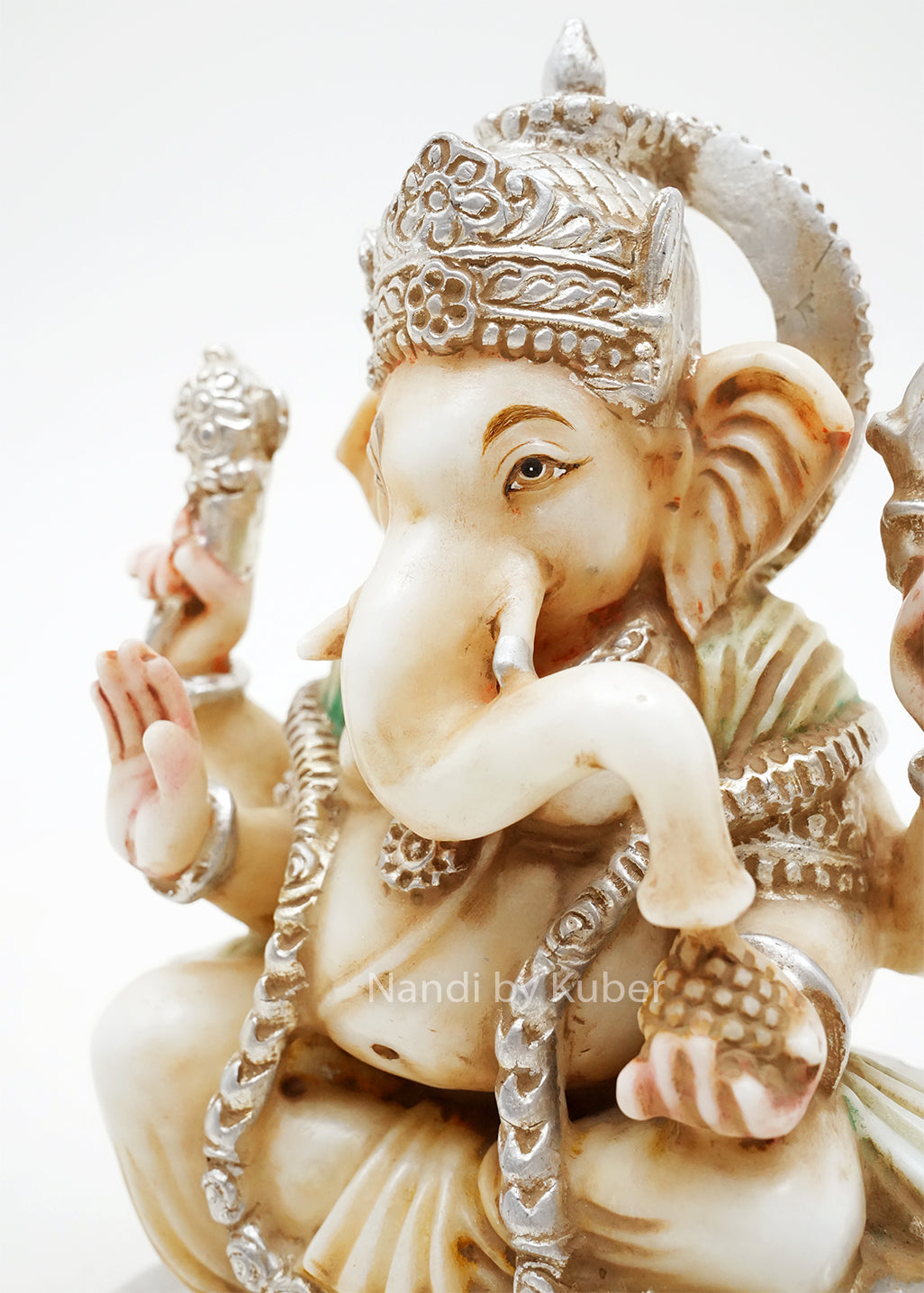 Handcrafted marble Ganesha idol seated on a lotus base with decorative silver finish and gemstone accents, ideal for home temples, spiritual décor, festive gifting, and Hindu worship spaces.