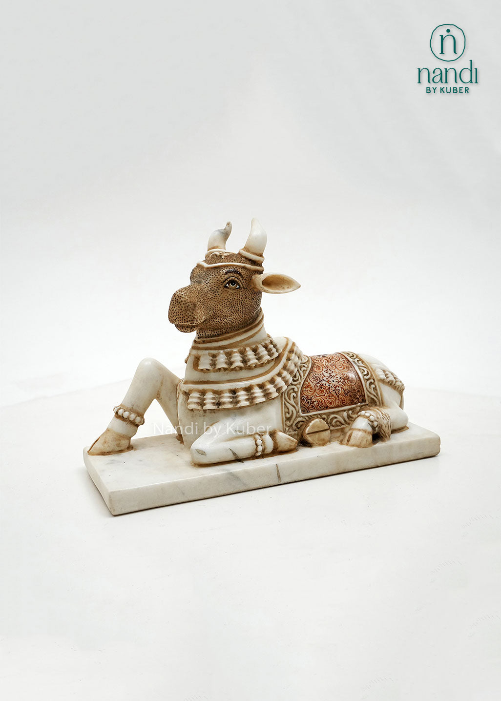 Handcrafted marble Nandi bull sculpture with antique finish and intricate detailing, inspired by Hindu temple art, ideal for spiritual décor, pooja spaces, and traditional home interiors.