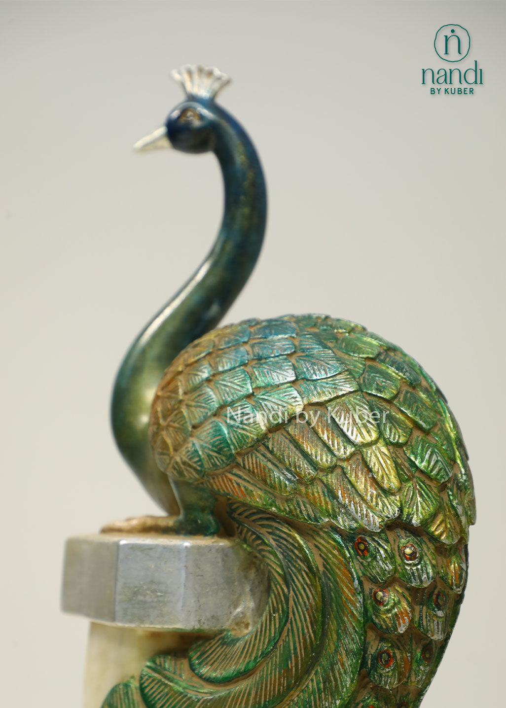 Decorative peacock sculpture on a marble-style pedestal with intricate detailing, ideal for adding elegance and artistic charm to any space.