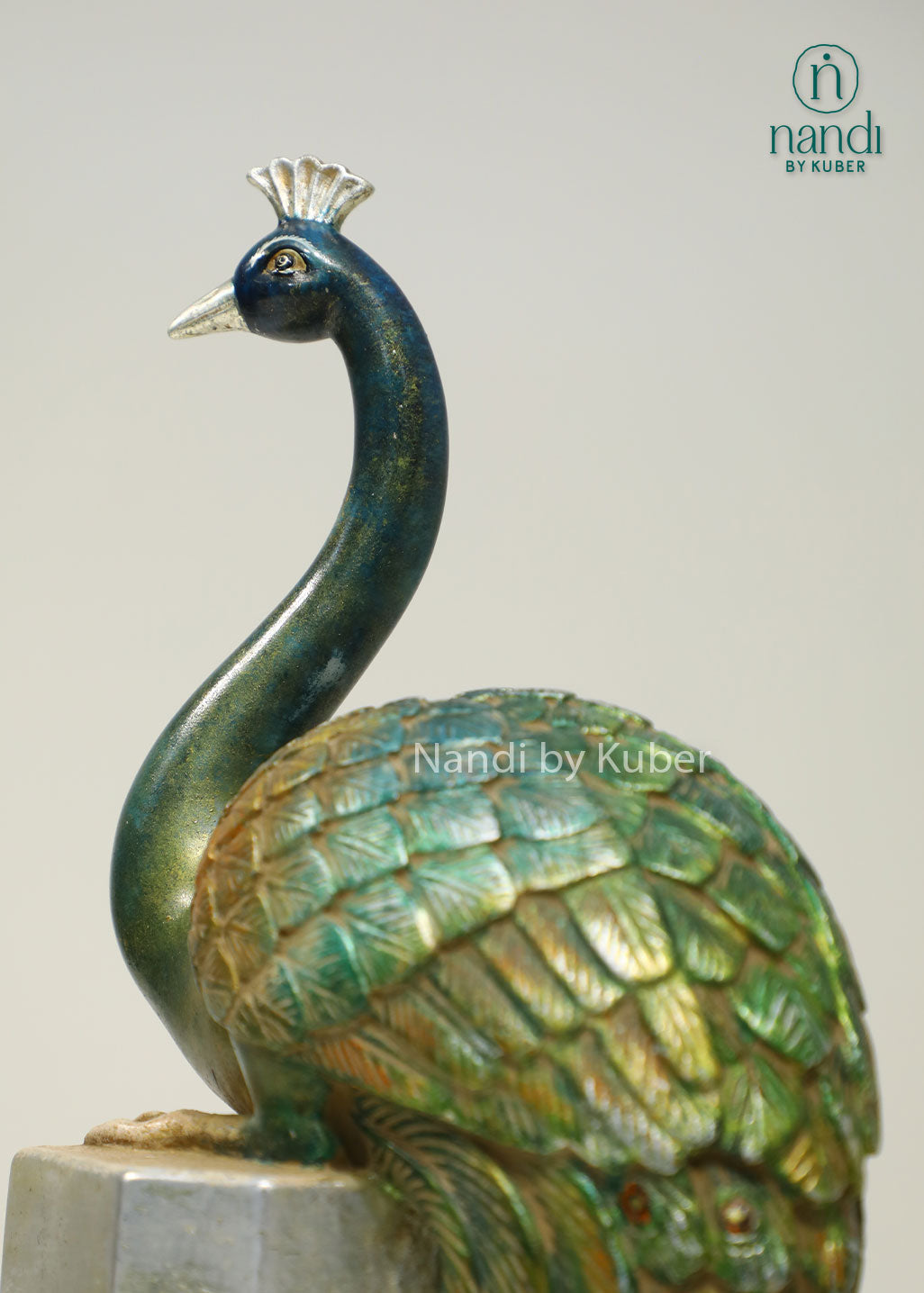 Decorative peacock sculpture on a marble-style pedestal with intricate detailing, ideal for adding elegance and artistic charm to any space.