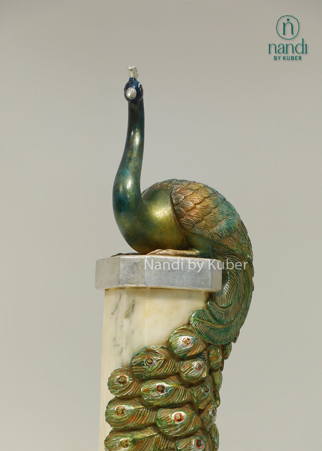 Decorative peacock sculpture on a marble-style pedestal with intricate detailing, ideal for adding elegance and artistic charm to any space.