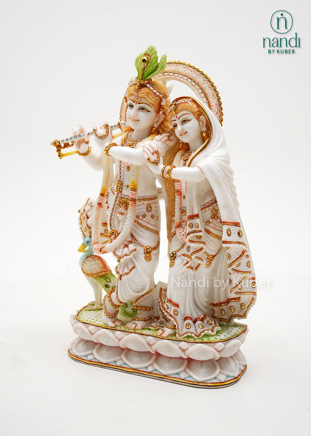 Handcrafted marble Radha Krishna idol with flute-playing Krishna, elegant gold embellishments, and lotus base, ideal for home temples, spiritual décor, devotional gifting, and traditional Indian interiors.