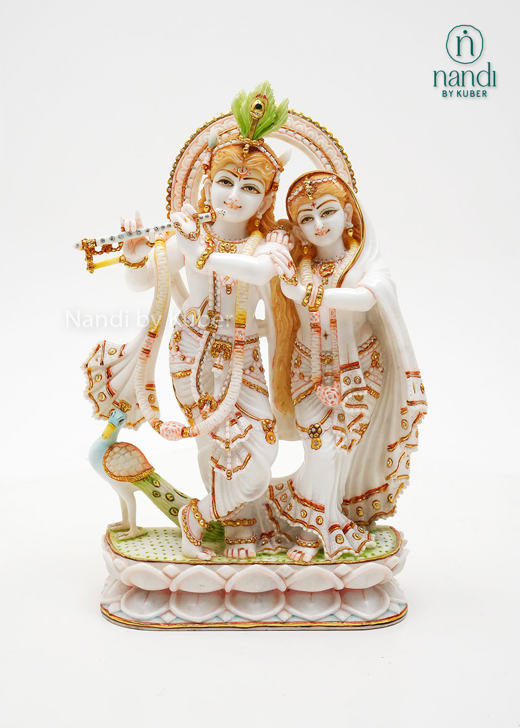 Handcrafted marble Radha Krishna idol with flute-playing Krishna, elegant gold embellishments, and lotus base, ideal for home temples, spiritual décor, devotional gifting, and traditional Indian interiors.
