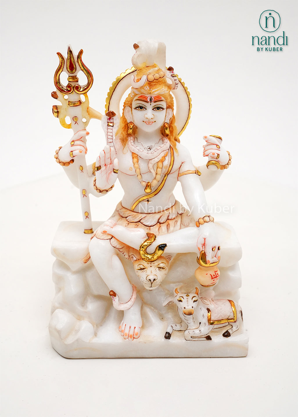Handcrafted white marble Lord Shiva idol with gold accents, trident, Nandi bull, and traditional Hindu symbolism, ideal for home temples, spiritual décor, and religious gifting.