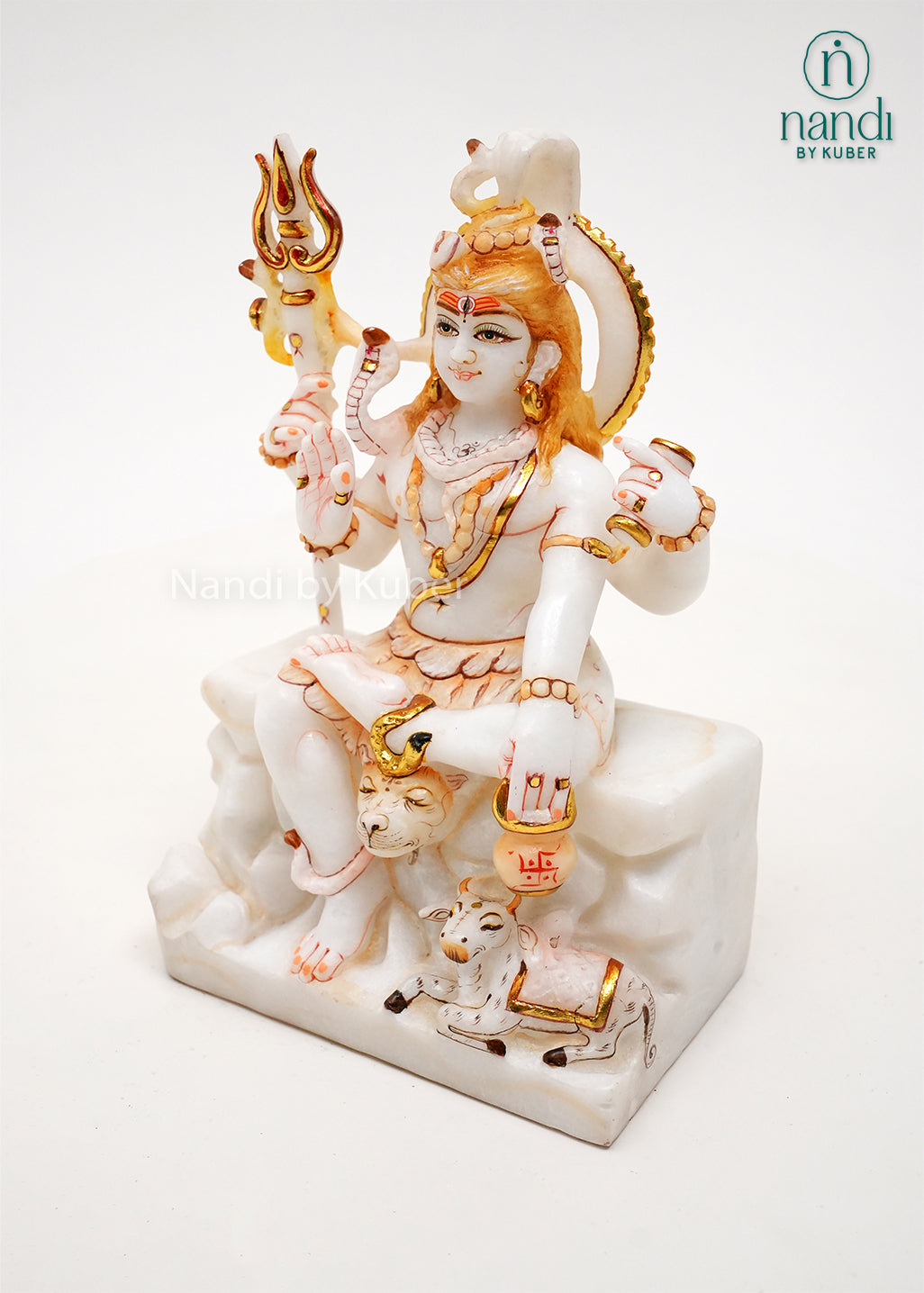 Handcrafted white marble Lord Shiva idol with gold accents, trident, Nandi bull, and traditional Hindu symbolism, ideal for home temples, spiritual décor, and religious gifting.