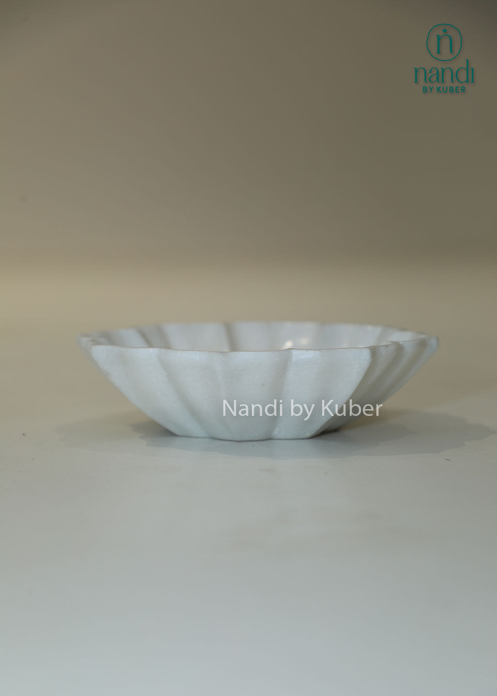 Handcrafted white marble urli bowl with decorative fluted edges and polished finish, ideal for floating flowers, candles, festive décor, centerpieces, and luxury home decoration.