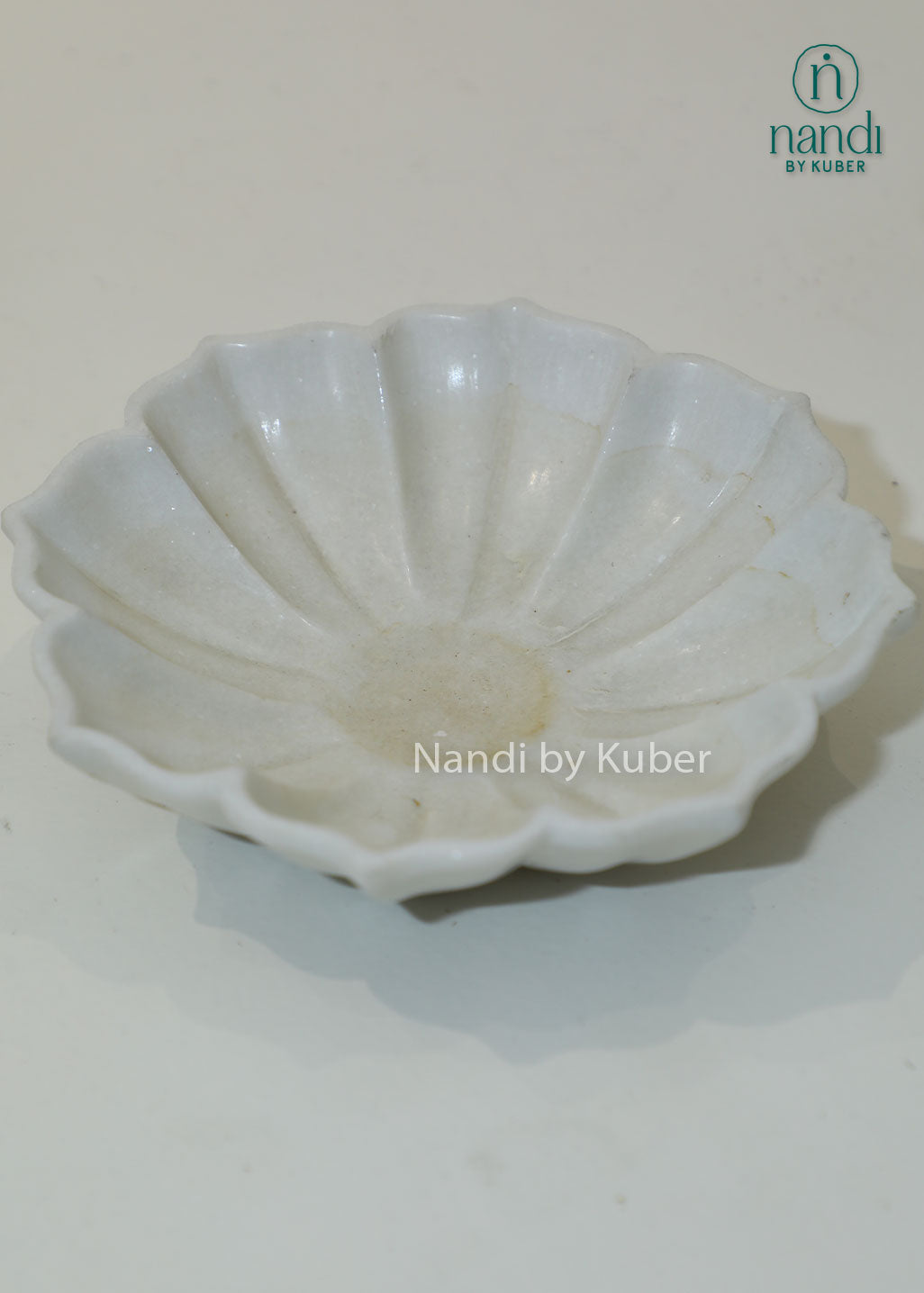 Handcrafted white marble urli bowl with decorative fluted edges and polished finish, ideal for floating flowers, candles, festive décor, centerpieces, and luxury home decoration.