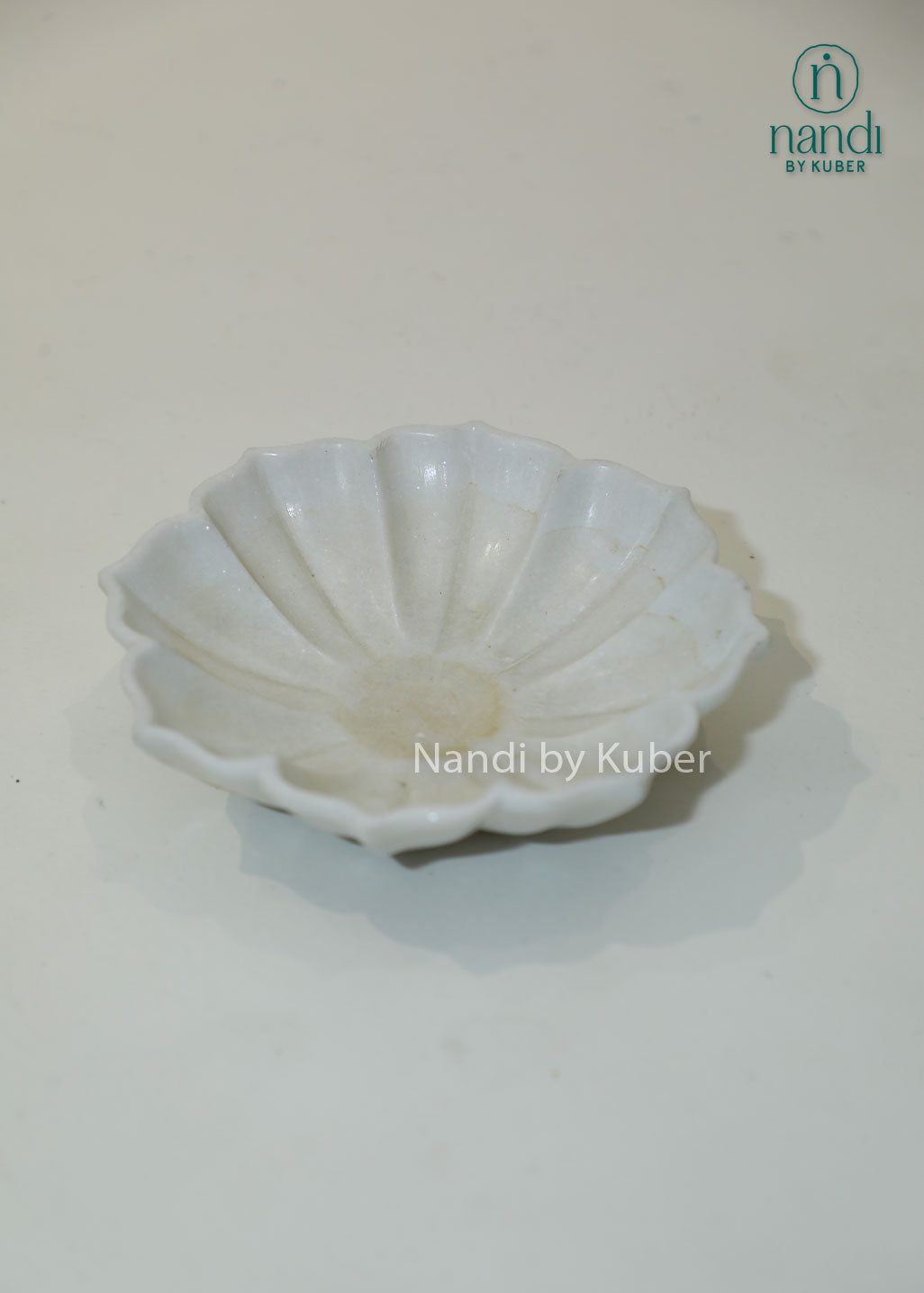 Handcrafted white marble urli bowl with decorative fluted edges and polished finish, ideal for floating flowers, candles, festive décor, centerpieces, and luxury home decoration.