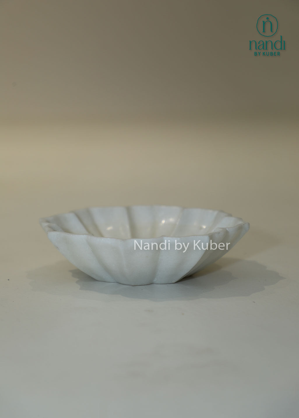 Handcrafted white marble urli bowl with decorative fluted edges and polished finish, ideal for floating flowers, candles, festive décor, centerpieces, and luxury home decoration.